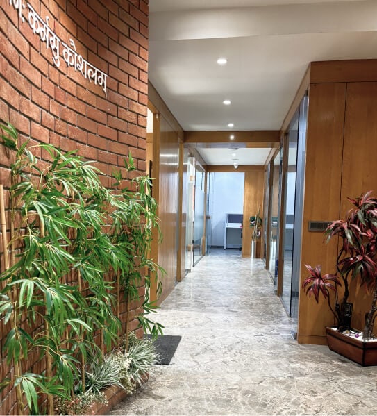 A corridor in the Aakash office lined with brick, timber panels and plants.