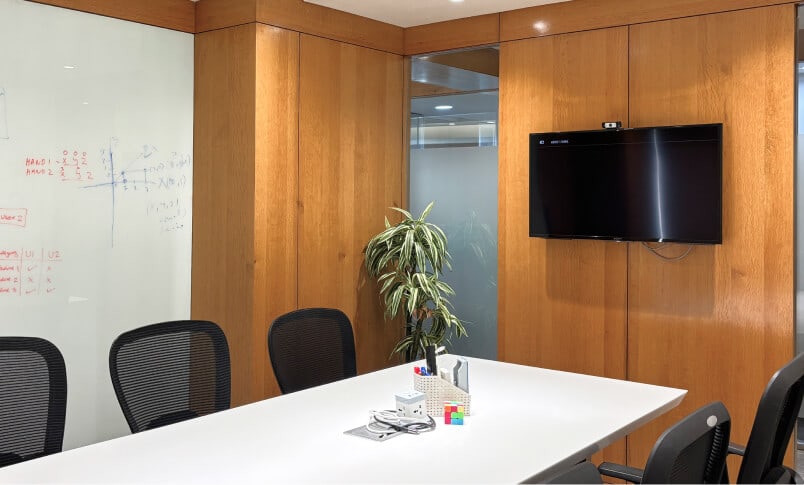 A meeting room in the Aakash office with a whiteboard, a long table and timber walls.