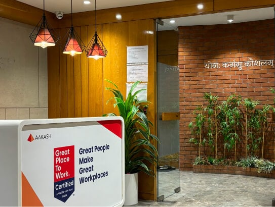 The Aakash reception, with a Great Place to Work sign in front of the brick wall.